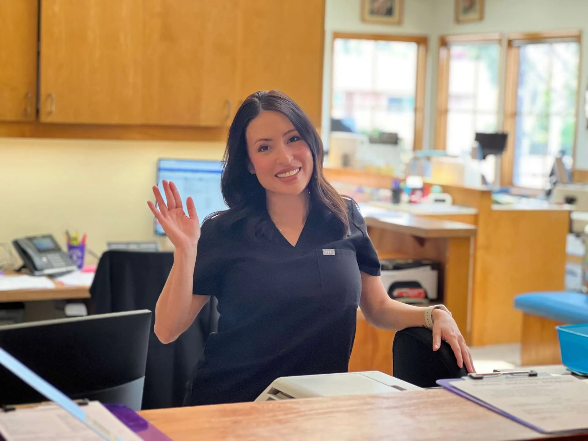 Team member at the front desk waving