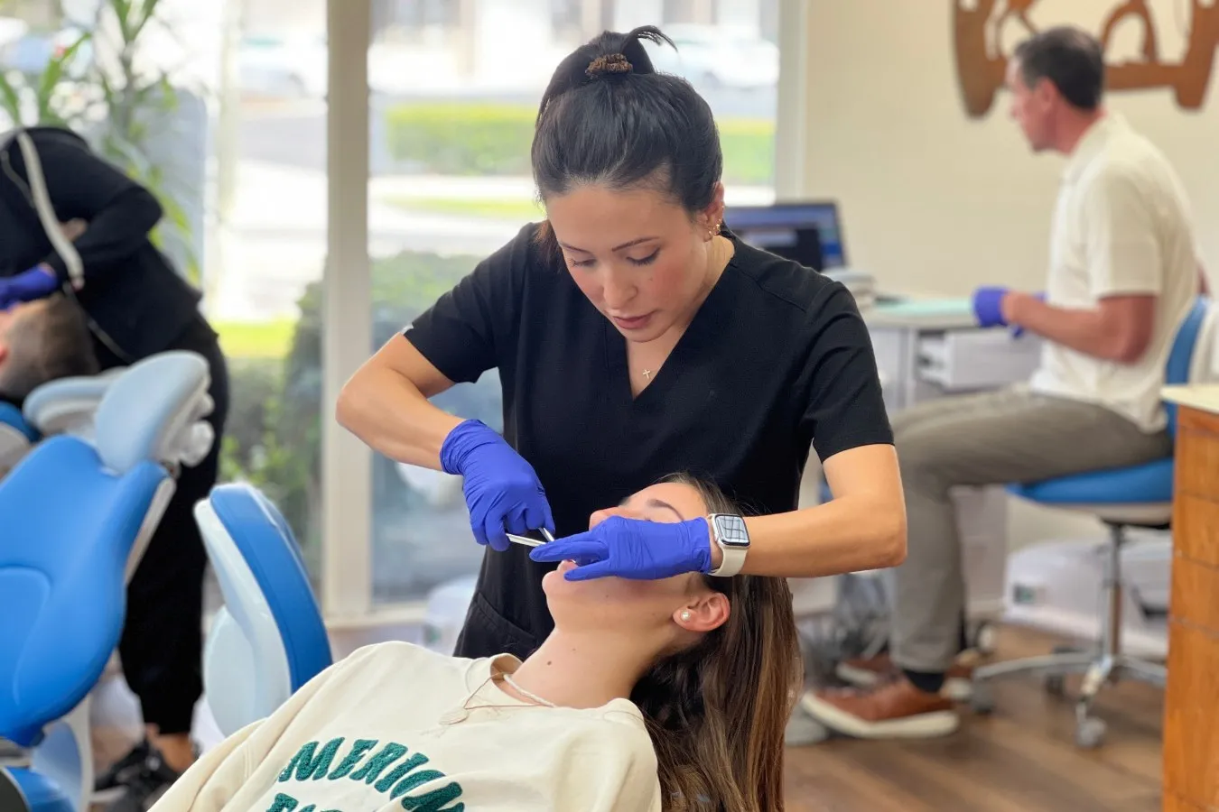 Team member examining patient's teeth