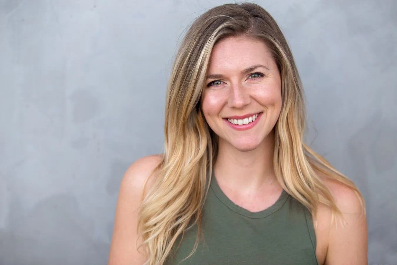 Smiling adult woman with straight teeth showcasing a confident smile, representing Invisalign treatment benefits at Potter Orthodontics.