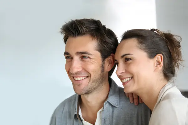 A man and woman smiling and looking to the side