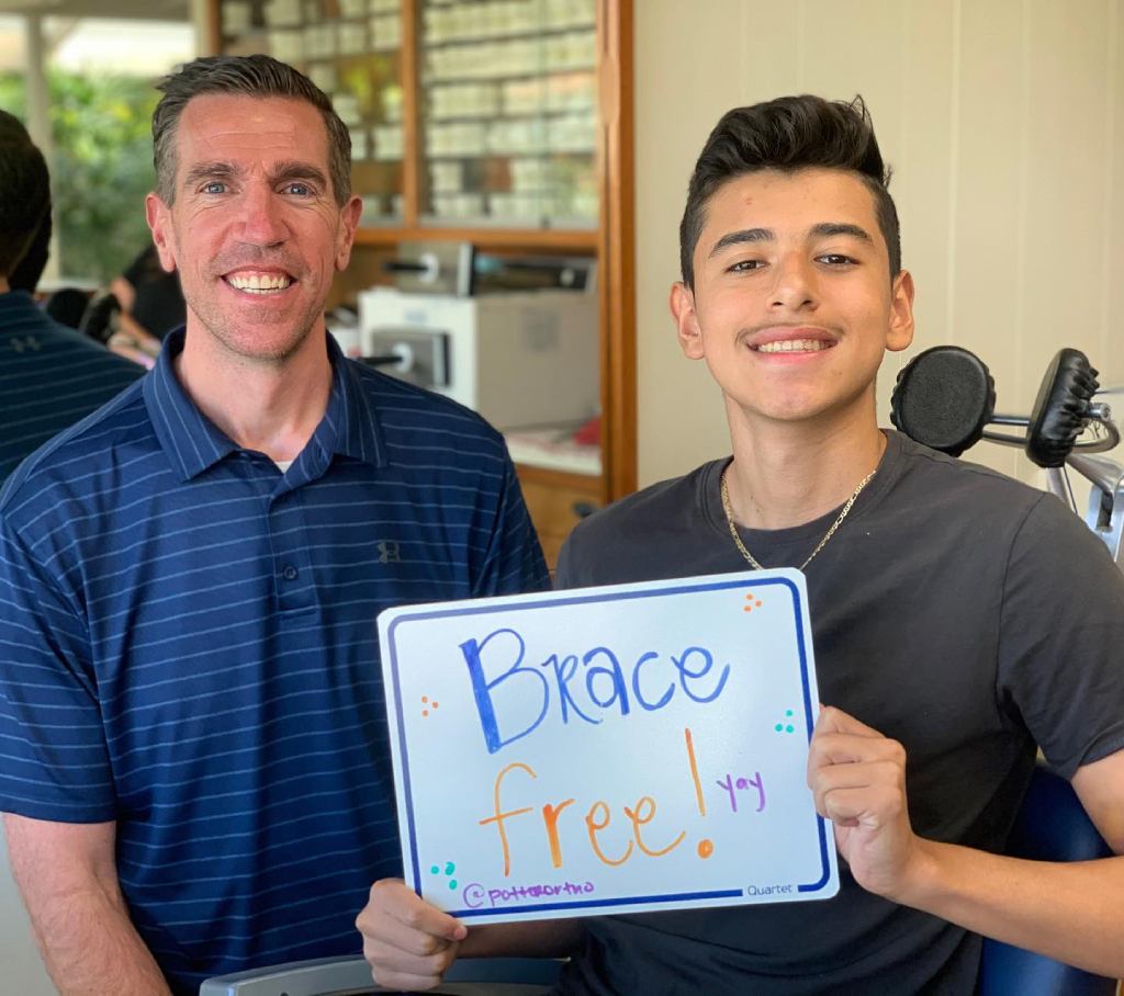Dr. Potter and a young man holding up a "Brace Free!" sign