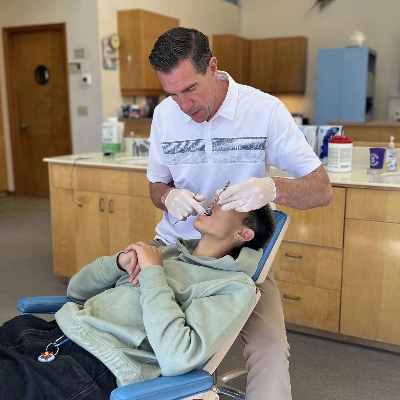 Orthodontist examining a patient in a dental office, focusing on orthodontic care and emergency management in Yorba Linda, CA.
