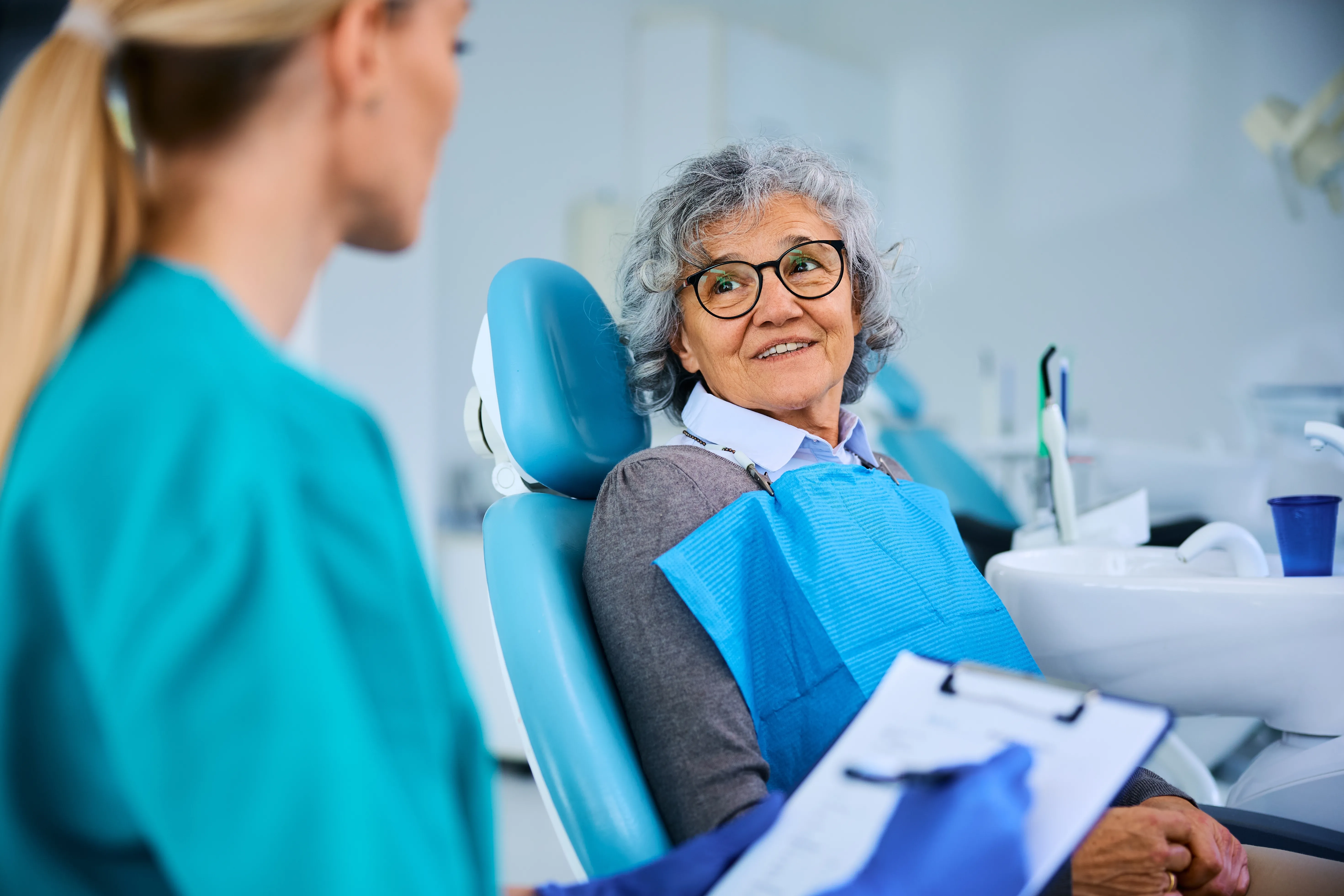 Older woman smiling in dental chair during consultation with orthodontist, highlighting adult orthodontic treatment options at Potter Orthodontics in Fullerton, CA.